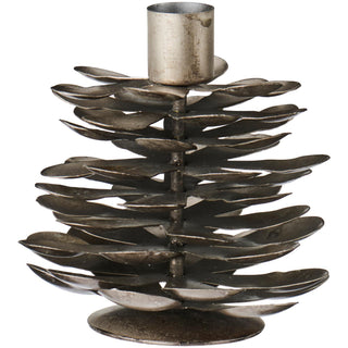Antiqued brass candle holder shaped like a layered pine cone with leaf-like plates and a candle socket on top, on a white background