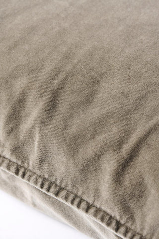 Close-up of a taupe velvet cushion corner showing its stitched seam detail