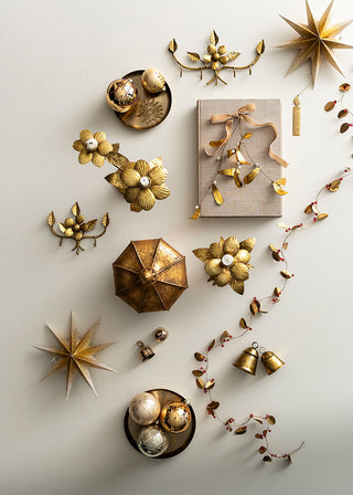 Gold decorative items including stars, flowers, and boxes on a light background