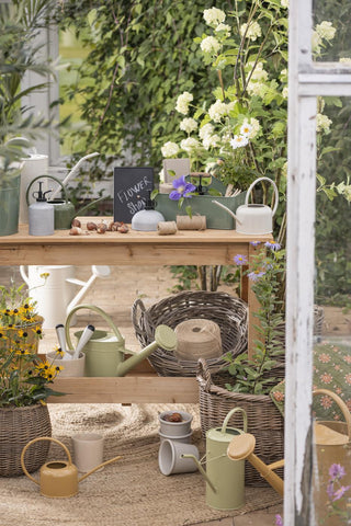 Kraft paper bags on a garden potting bench display with watering cans, baskets, and twine